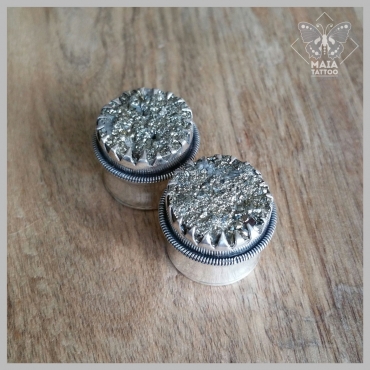 Fotografia di due plugs in argento con incastonate pietre in ematite grezze, realizzati a mano da Mysteeco Unique Body Jewellery, disponibili presso il Maia Tattoo di Cornaredo Milano