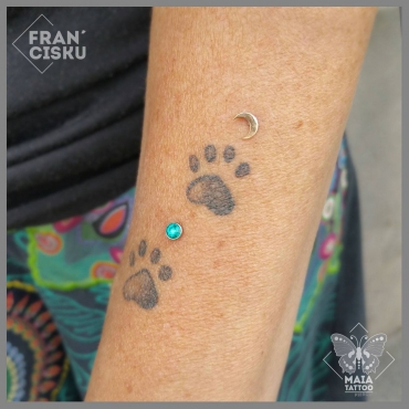 Fotografia di un avambraccio di donna con due microdermal, un brillantivo verde e uno a forma di luna ora di 18k di Anatometal, eseguiti da Francesco Deschino presso il Maia Tattoo di Milano Cornaredo