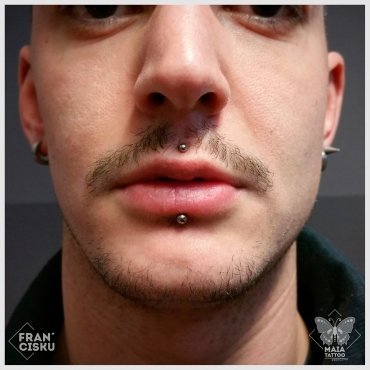 Fotografia di un viso di ragazzo con due piercing su labbro superiore (medusa) e su inferiore (labret) eseguiti da francesco deschino presso il Maia Tattoo di Milano Cornaredo
