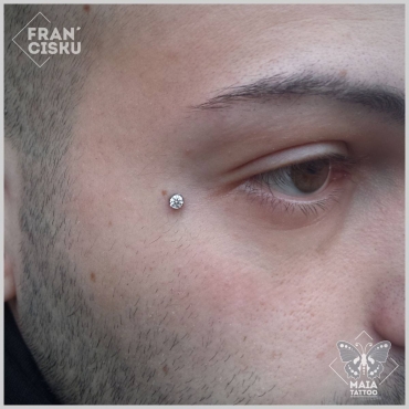 Fotografia di un viso di uomo con microdermal su zigomo con zircone bianco, eseguito da Francesco Deschino presso il Maia Tattoo di Milano Cornaredo