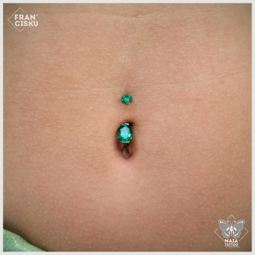 Fotografia di un piercing all'ombelico con gioiello Industrial Strength con zirconi swarovski verde alpinite incastonati con taglio ovale, eseguito da Francesco Deschino al Maia Tattoo di Milano Cornaredo